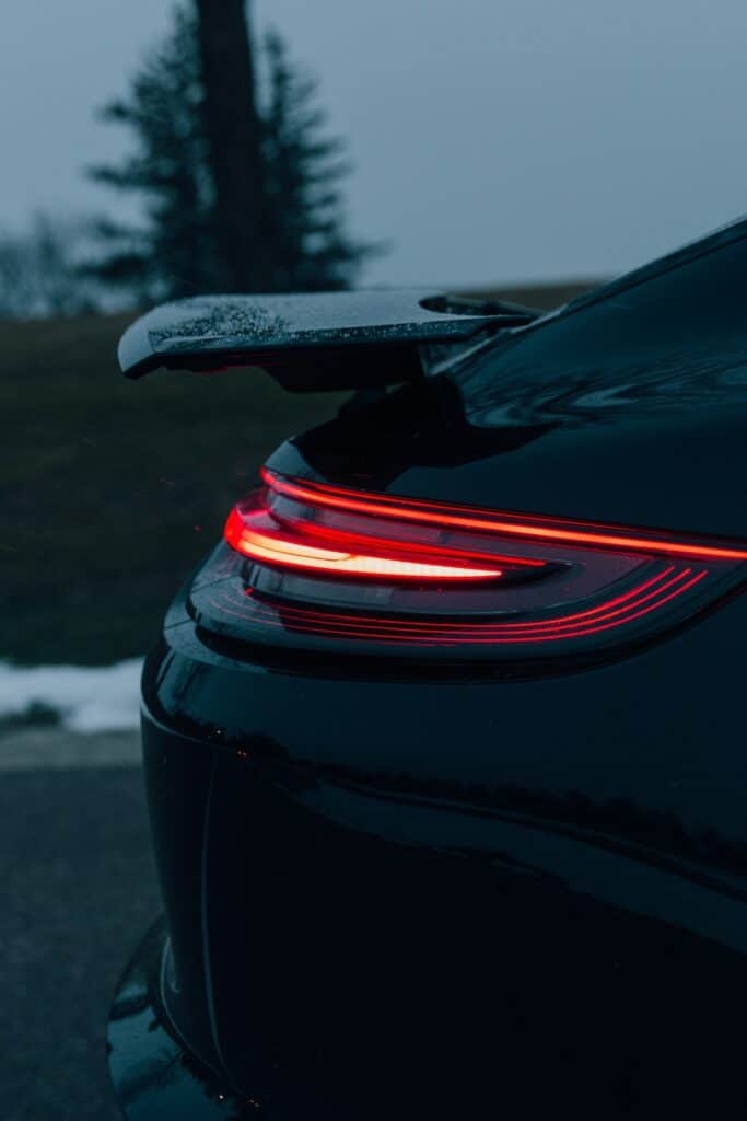 Détail du feu arrière rouge d'une Porsche 911 noire au crépuscule