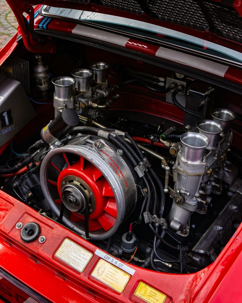 Compartiment moteur d'une Porsche 911 classique : flat-six refroidi par air, turbine de refroidissement et carburateurs