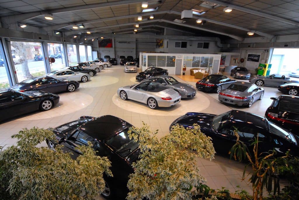Showroom FLAT rempli de Porsche 911 et Boxster, vu en plongée