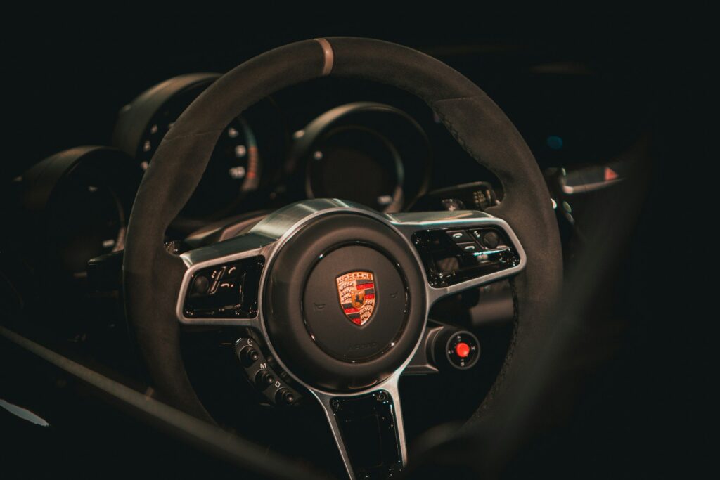 Volant Porsche en alcantara avec sélecteur de mode, dans la pénombre